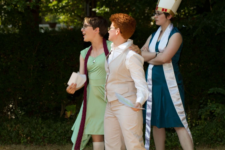 three women in costumes posing together outside