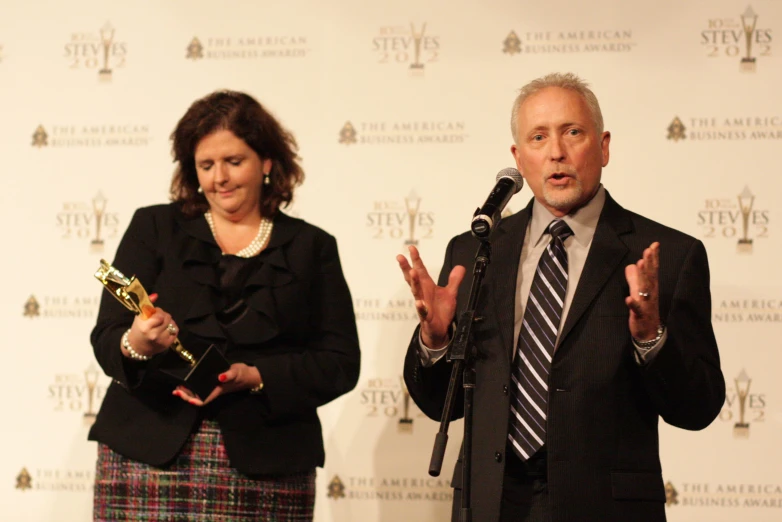 an old man and woman at a podium