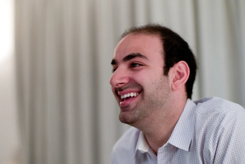 a man smiles as he holds his camera up