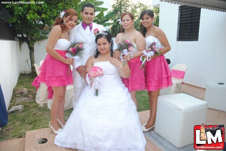 a bride poses with her four bridesmaids outside