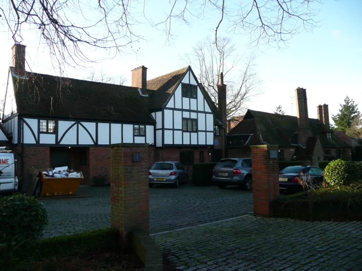 two white and black houses in the street with cars