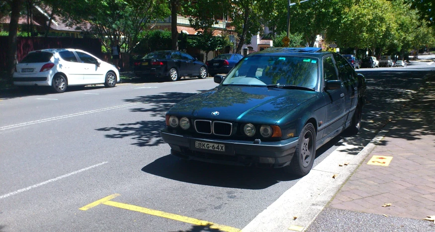 a small blue car parked on the side of the road