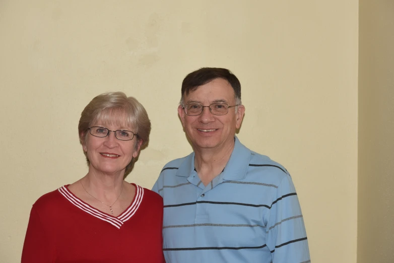 an older man standing next to a younger woman