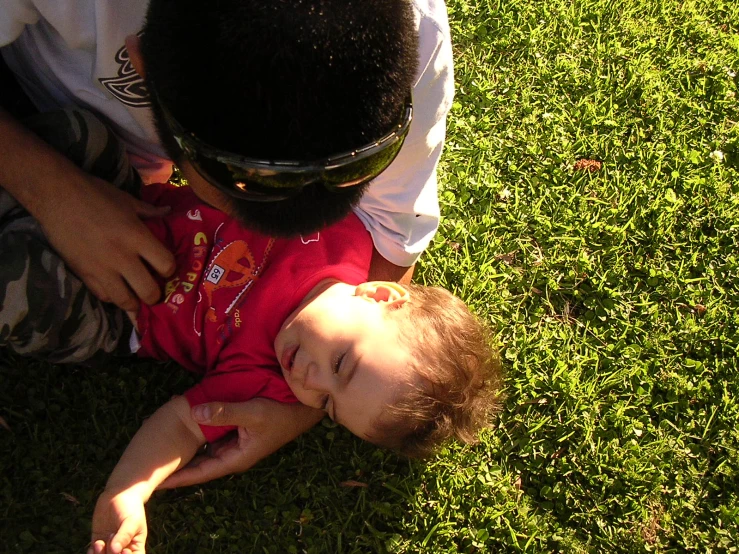 man holding baby on his lap while looking at camera