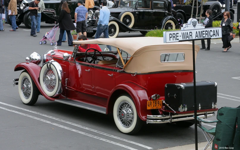 the old fashion car is parked on the road