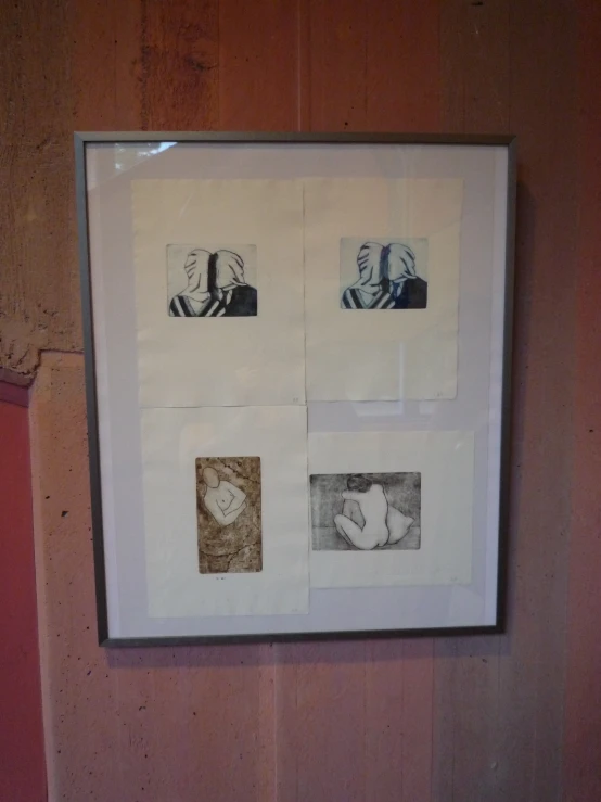 four frames displaying pos and drawings hanging on wall