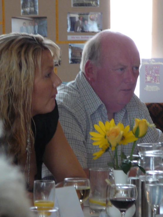 there is a man and woman sitting at a table with wine glasses