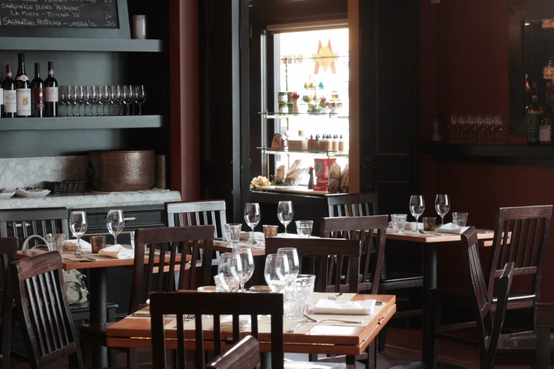 a table set up with wine glasses and a menu in front of a bar