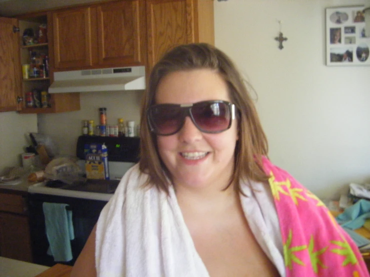 a smiling woman is wrapped up in a bath robe