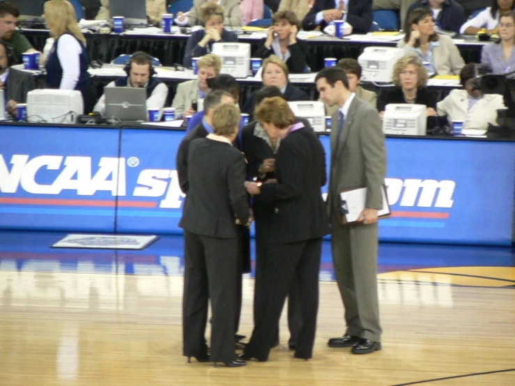 three men are talking while standing in a court