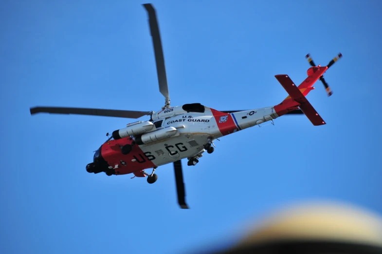 a helicopter flying across a blue sky with propellers