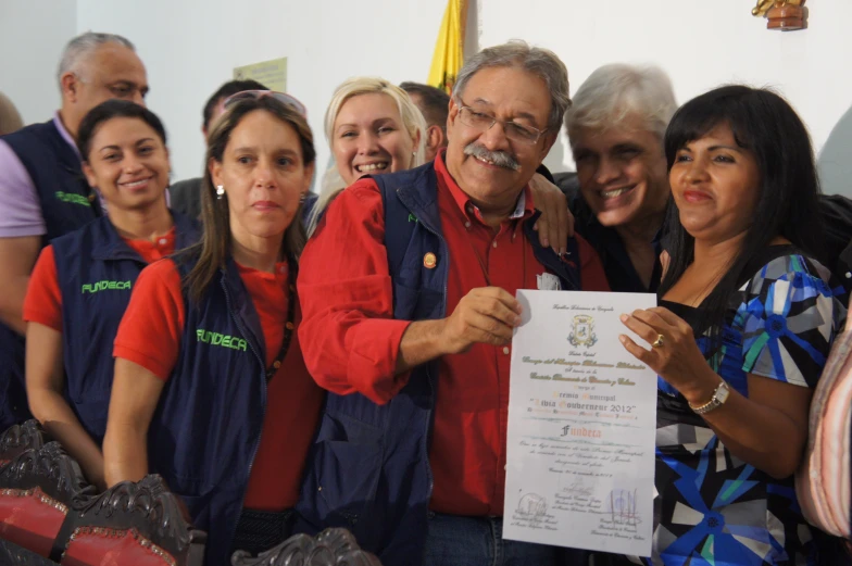 a group of people pose for a po holding a white paper