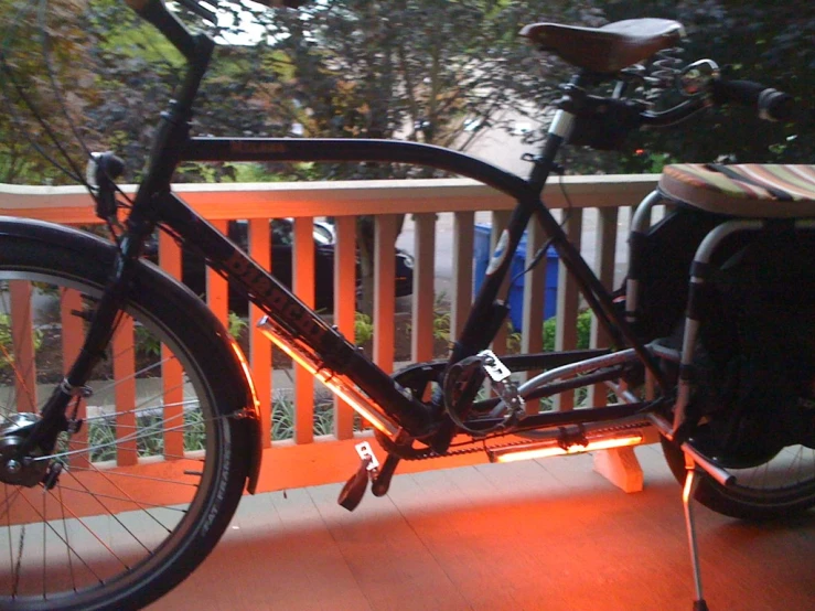 a bicycle is parked on a deck with orange lights