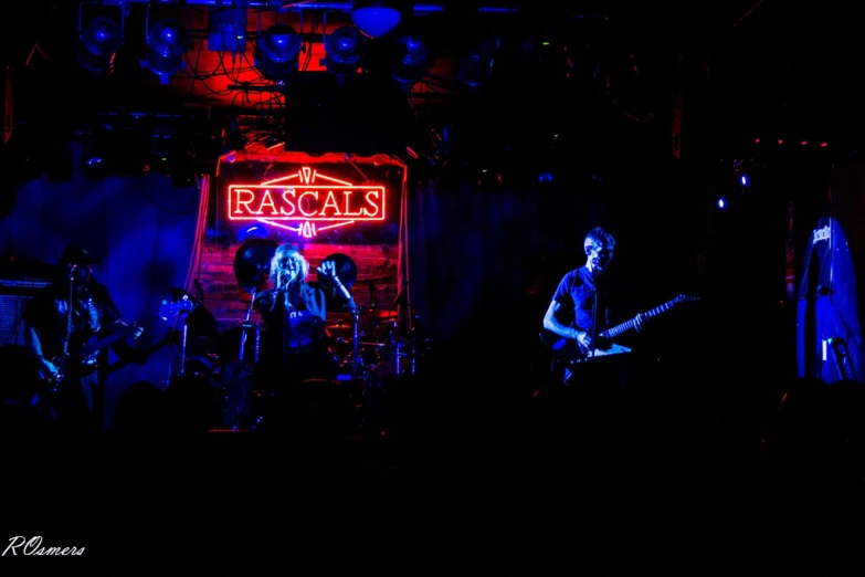 the band rasca is playing in a dark room