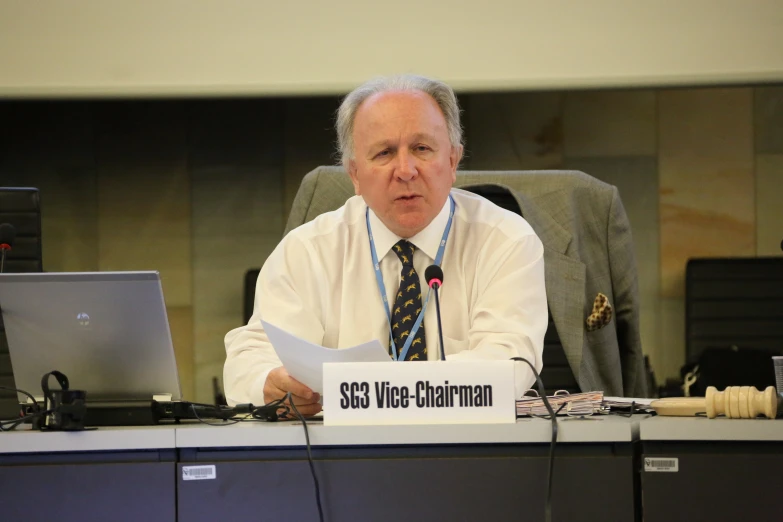 a man in a tie looks at soing at a table