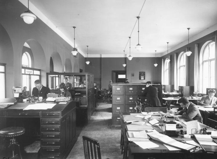 people working in a large office with many tables