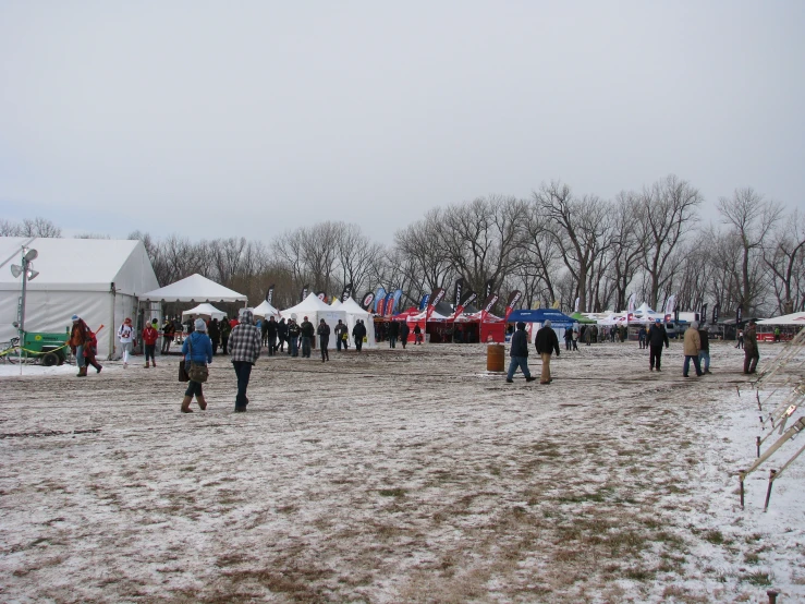 many people walking and some have tents near trees