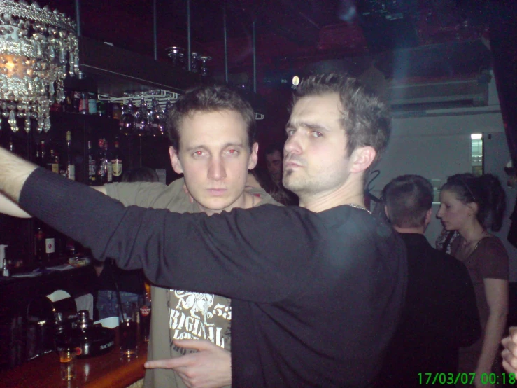 two people standing in a bar one pointing at a light