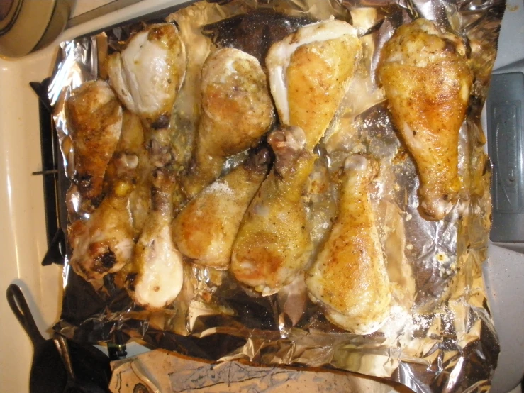 a bunch of chicken wings are placed in a tin foil wrap