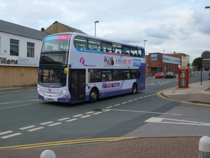 a blue and white double decker bus driving down a street