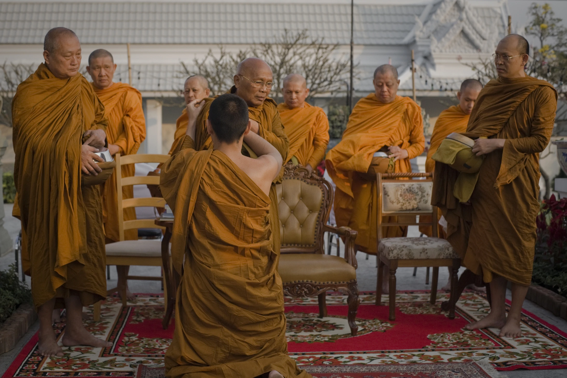 people standing and sitting around a table with many books