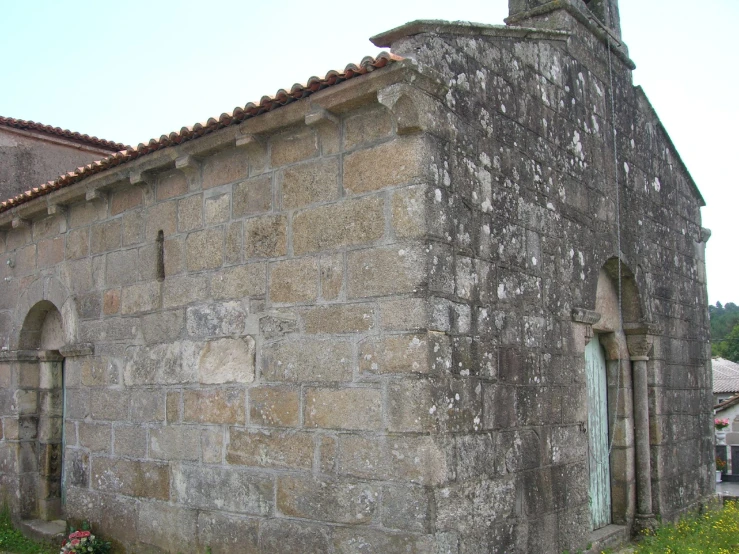 a very old building with windows and doors in front