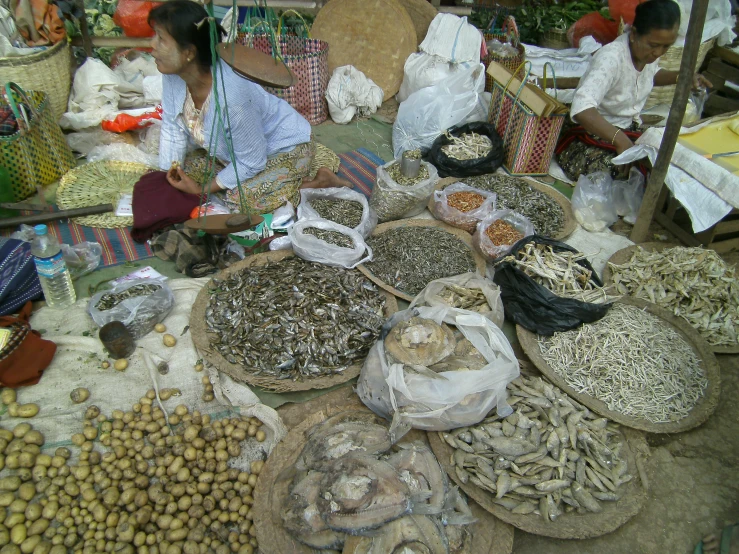 people shop in a market selling nuts and other foods