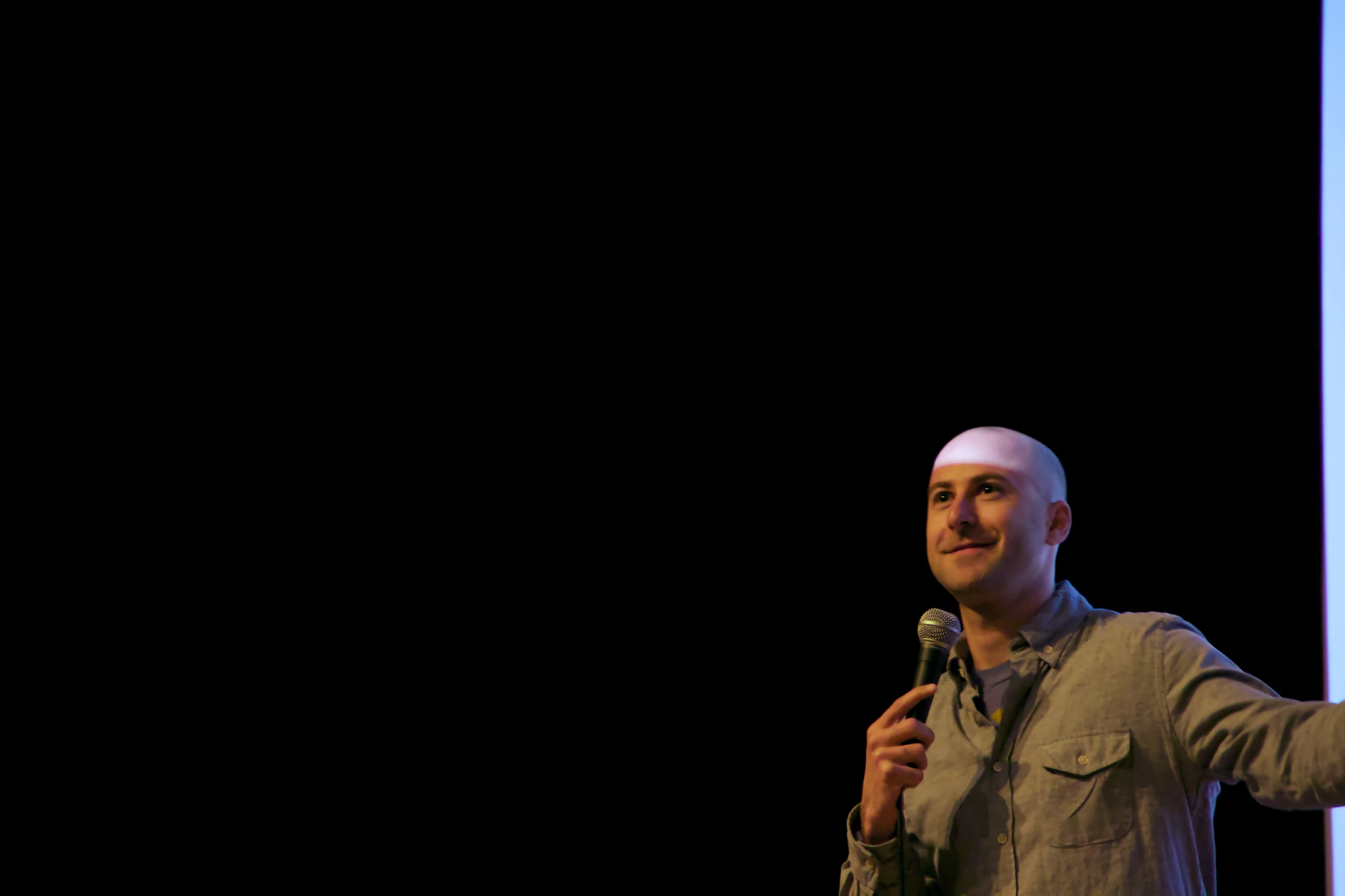 a man standing in front of a microphone in his left hand