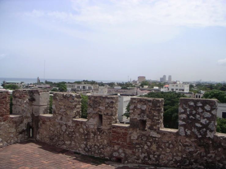 a view of a city and its surrounding wall from atop an old brick structure