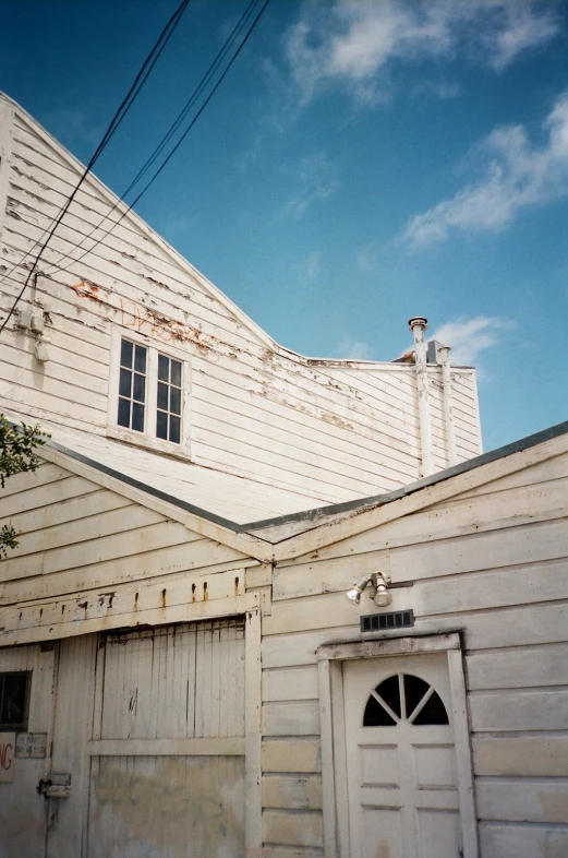 an old white house has been boarded to the side