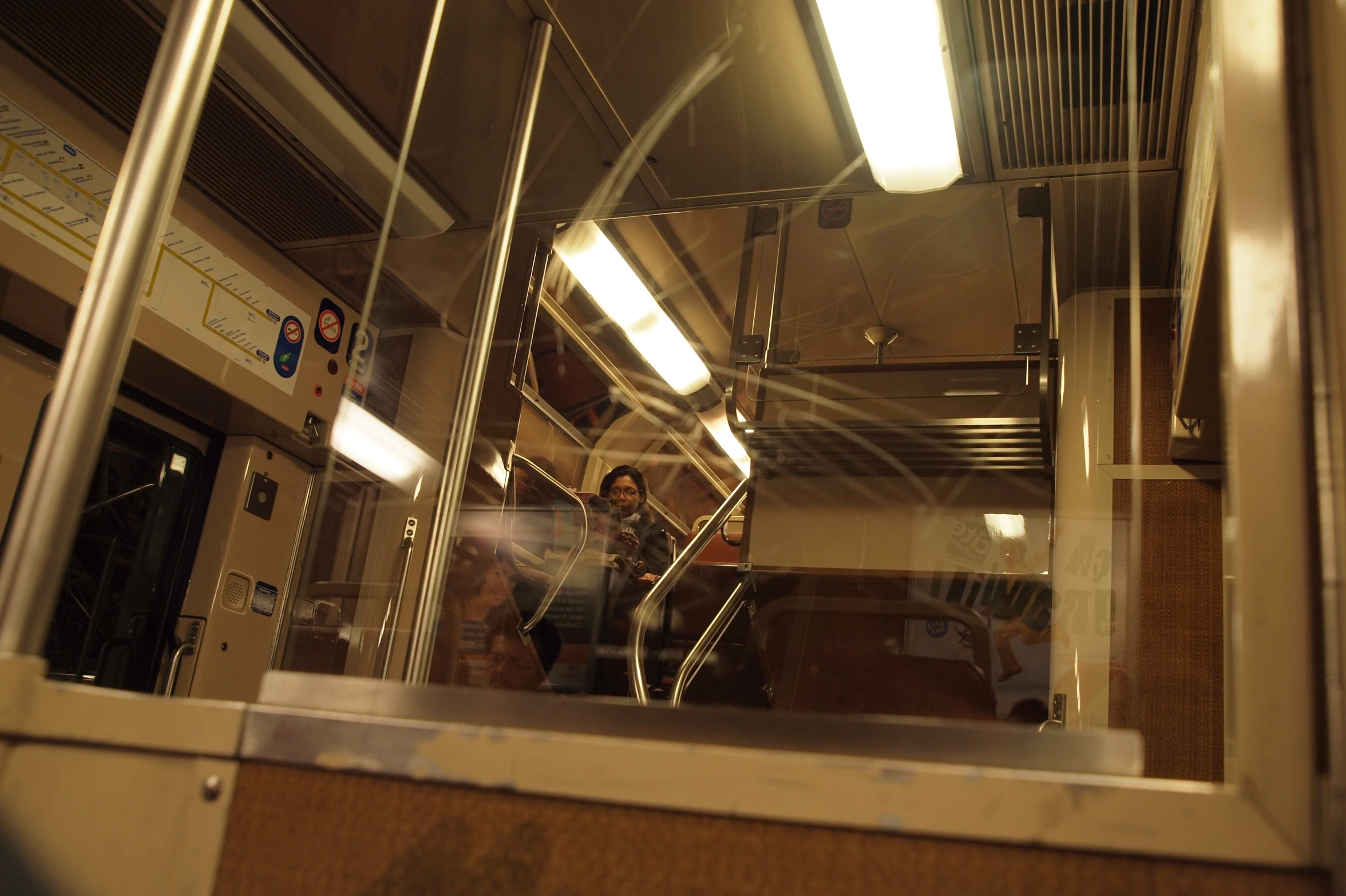the reflection of a man walking down a train