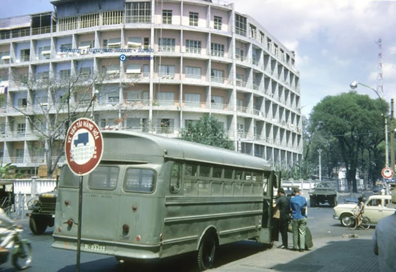 vintage bus with sign at intersection in large city