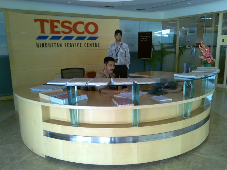 two men sitting at a desk in an office