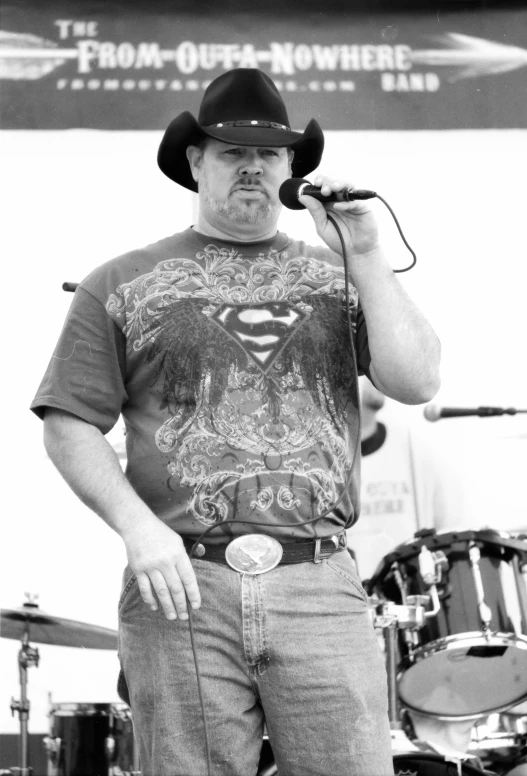 man in a superman shirt singing into a microphone