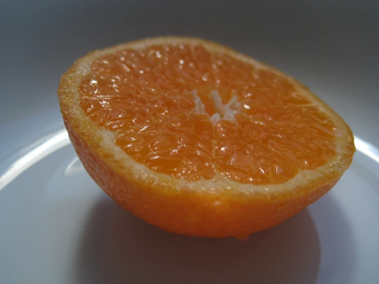 an orange that is half eaten sitting on a plate