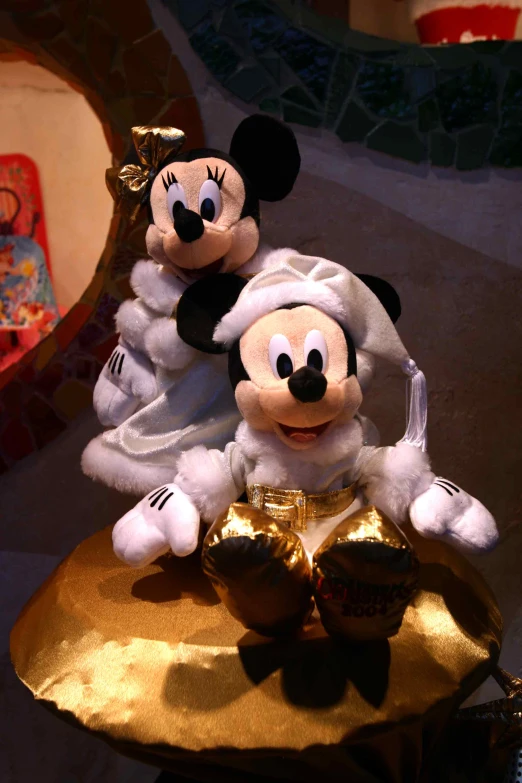 two stuffed mice in costume sitting on a table