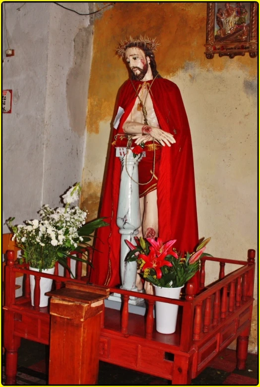 a statue of jesus with a crown, and a basket filled with flowers