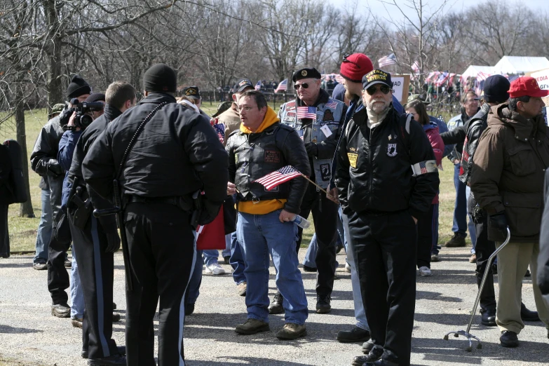 many men stand together in line on a sidewalk