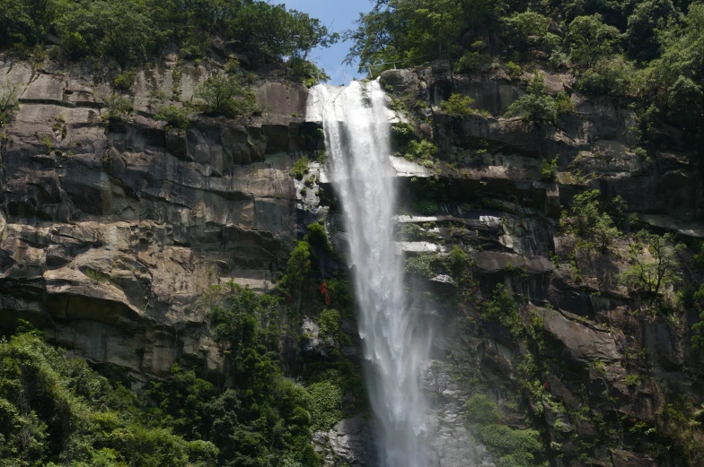 the tall waterfall is being observed from below