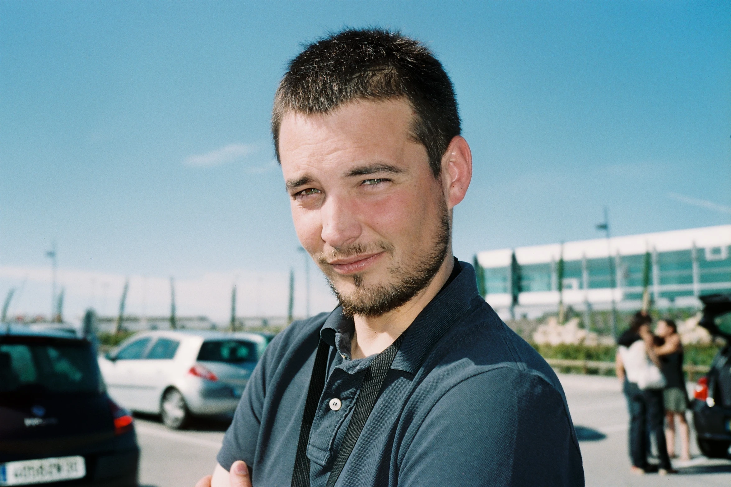 a man standing in front of a car on a busy street