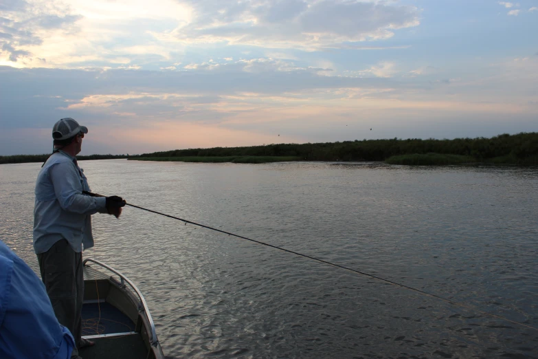 the man fishing on the water has a pole