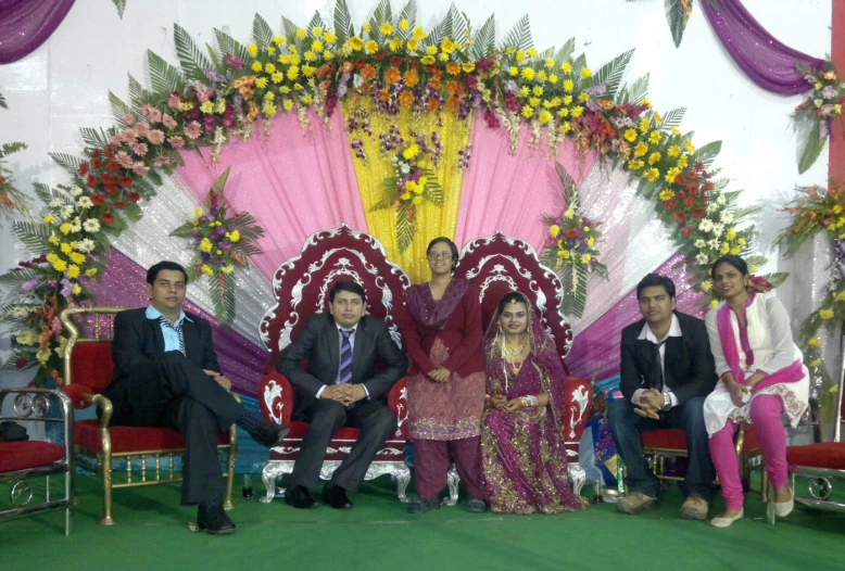 an indian family sitting on a decorated stage