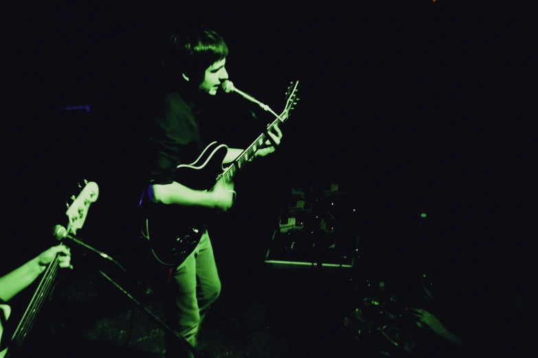 a man holding an electric guitar while standing on stage