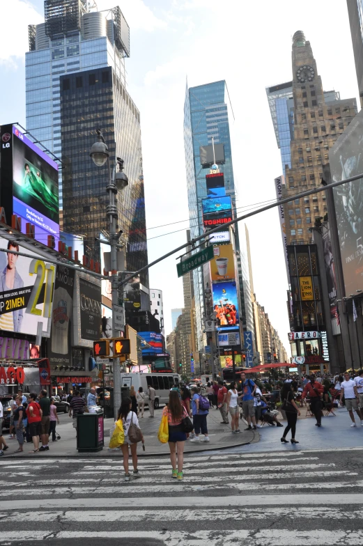 people walking on an intersection with multiple billboards