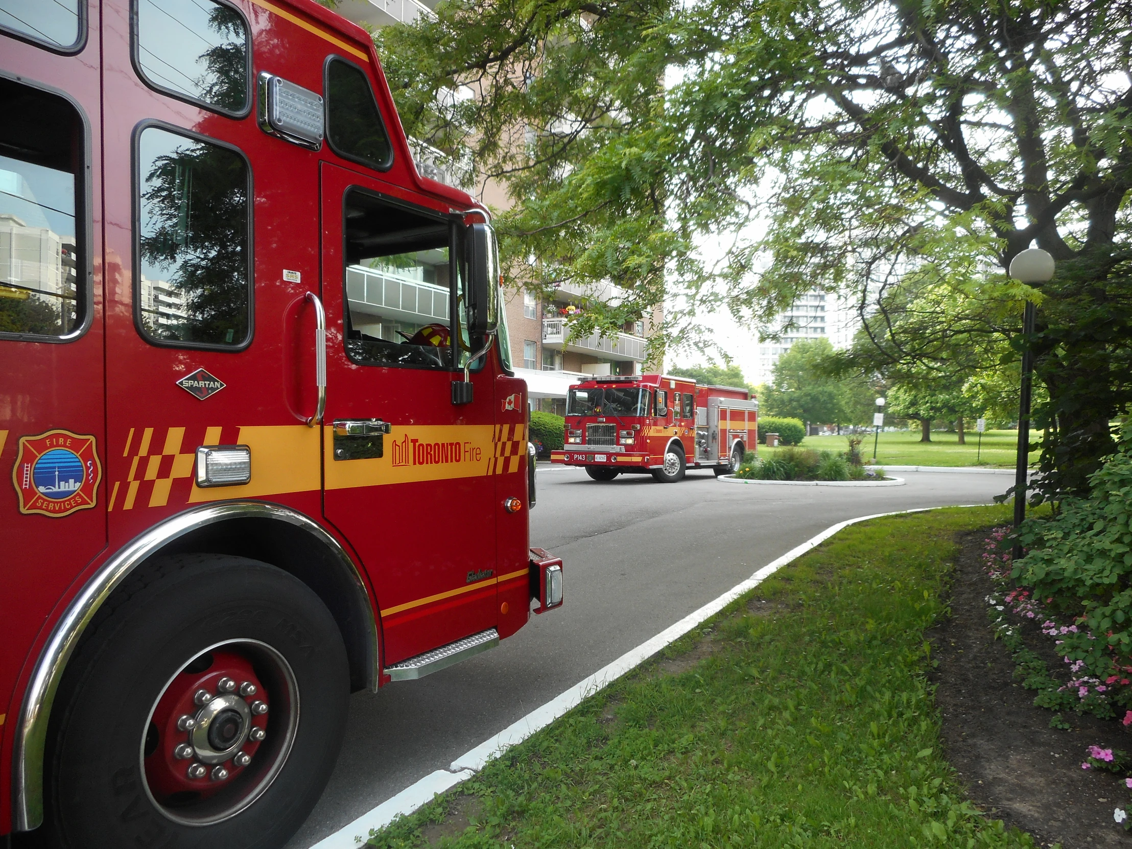 two fire trucks passing by on a city street