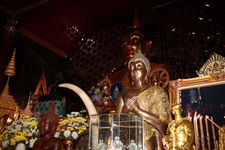 a statue inside a temple in front of a mirror