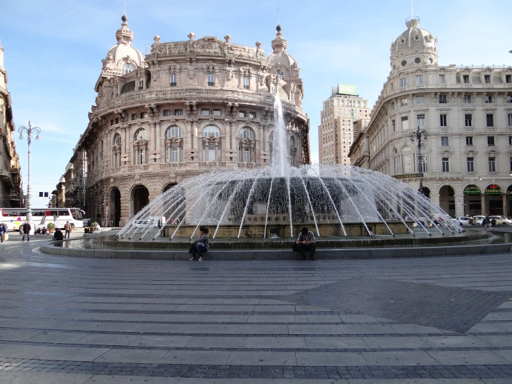 the fountain with water is surrounded by large buildings
