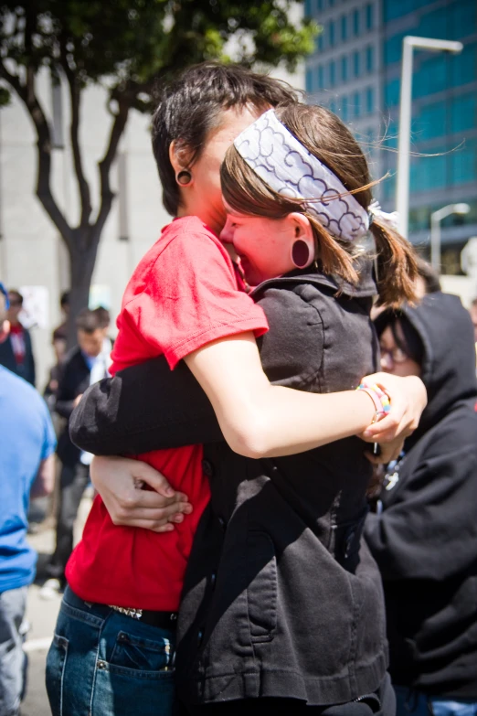 two people hugging while walking in the city