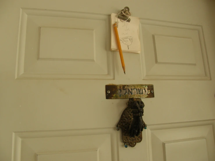 a sign and some gloves hanging from the door