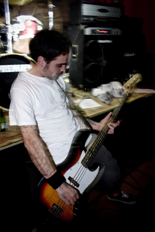 a man in a white shirt playing a bass